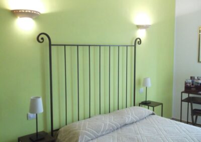 Camera Margherita con pareti verdi e letto in ferro