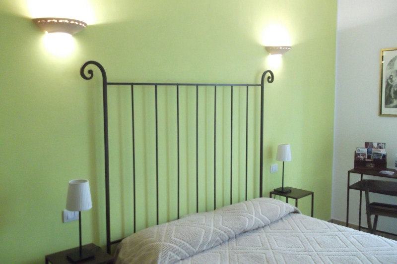 Camera Margherita con pareti verdi e letto in ferro