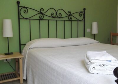 Camera Quadrifoglio con letto in ferro e pareti verdi