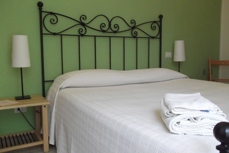 Camera Quadrifoglio con letto in ferro e pareti verdi