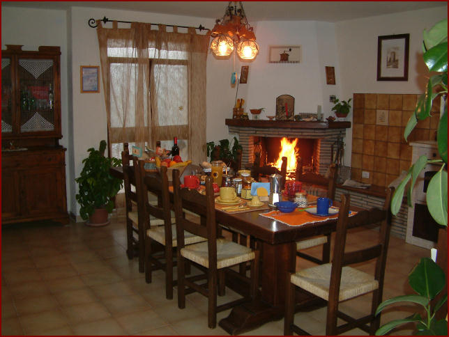 Sala comune con tavola apparecchiata e camino